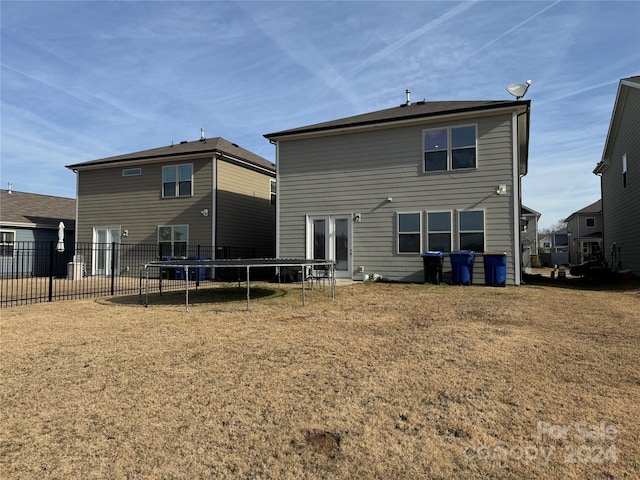 rear view of property with a trampoline