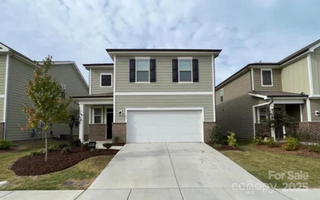3033 Eastcott Ave, Monroe, NC 28110 - view of front of property with a garage, brick siding, and concrete driveway