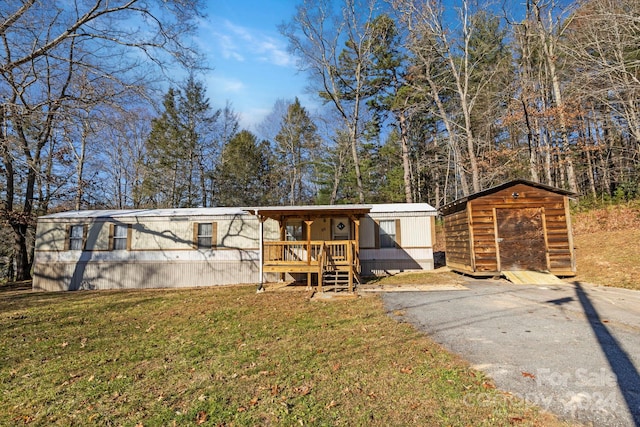 view of front of home featuring a storage shed and a front yard