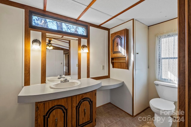 bathroom with tile patterned flooring, ceiling fan, toilet, and vanity