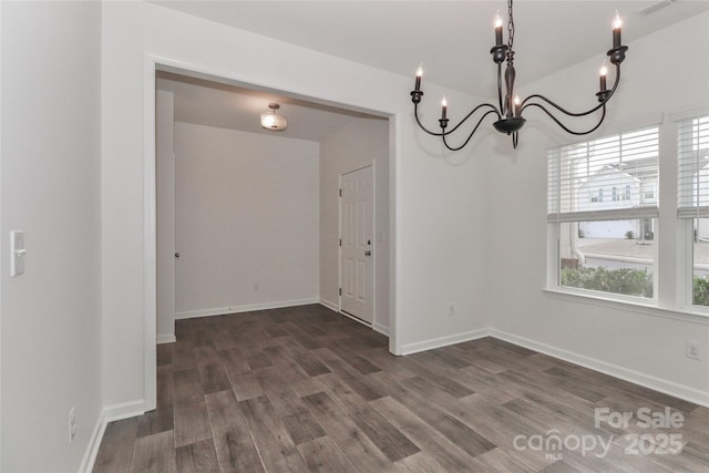 unfurnished dining area featuring a chandelier and dark wood-type flooring