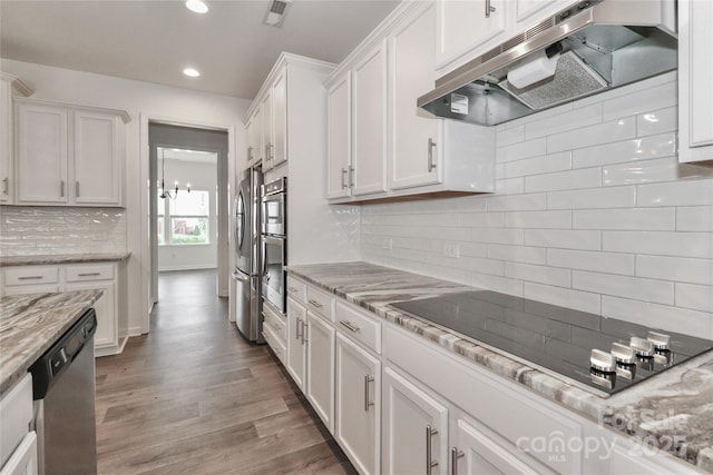 kitchen with light stone counters, appliances with stainless steel finishes, tasteful backsplash, dark hardwood / wood-style flooring, and white cabinetry