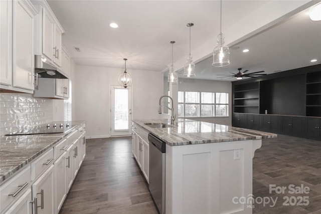 kitchen featuring black electric stovetop, hanging light fixtures, stainless steel dishwasher, an island with sink, and white cabinetry