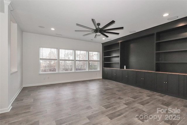 unfurnished room with built in shelves, ceiling fan, and hardwood / wood-style floors