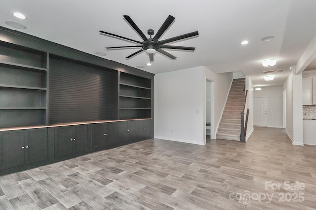 unfurnished living room with light hardwood / wood-style flooring, built in features, and ceiling fan