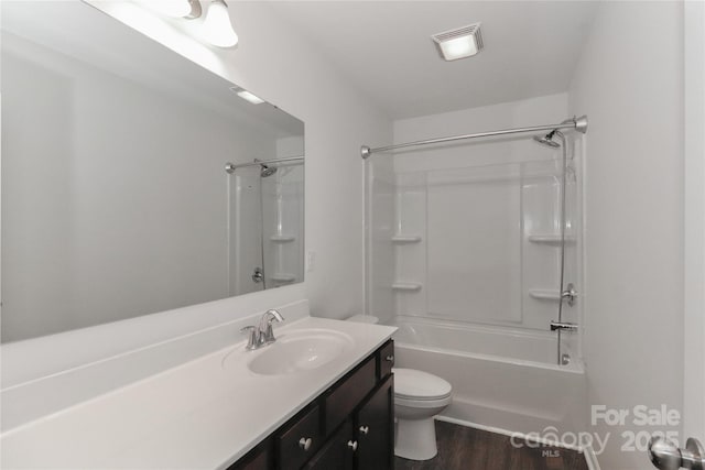 full bathroom featuring hardwood / wood-style floors, vanity, tub / shower combination, and toilet