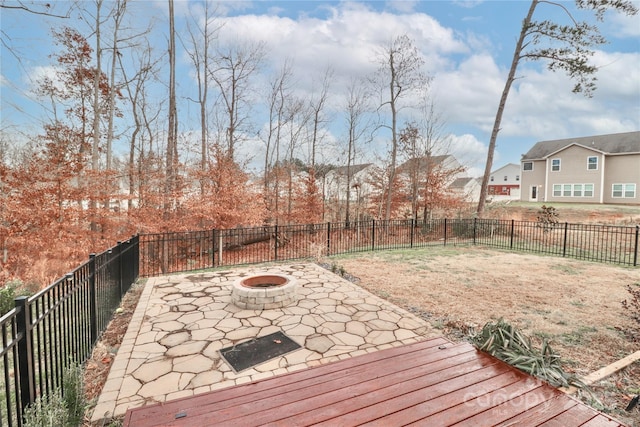 wooden terrace featuring a patio and a fire pit