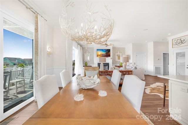 dining room with ceiling fan, wood-type flooring, and ornamental molding