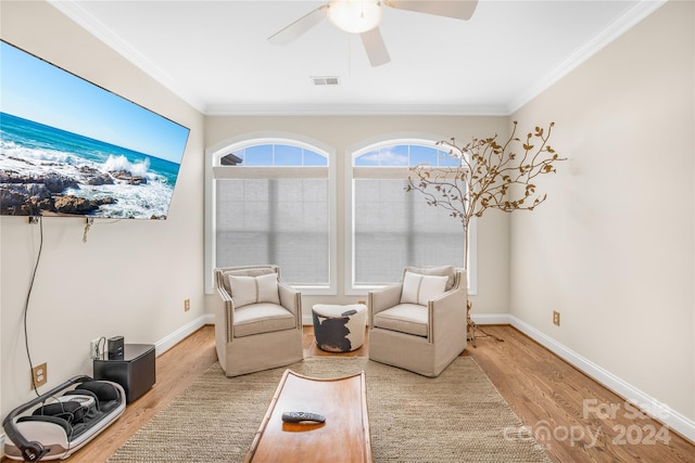 living area featuring ceiling fan, light wood-type flooring, and ornamental molding