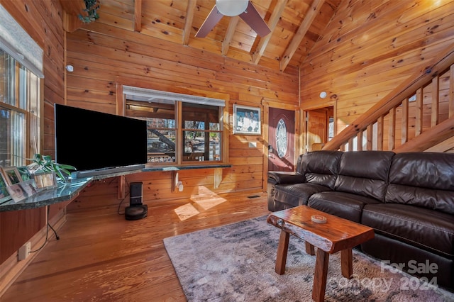 living room featuring beamed ceiling, plenty of natural light, wood-type flooring, and high vaulted ceiling