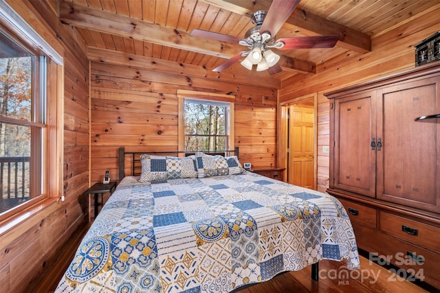 bedroom with wooden walls, beamed ceiling, wooden ceiling, and dark hardwood / wood-style floors