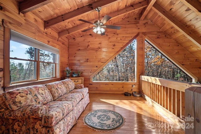 living room featuring a wealth of natural light, lofted ceiling with beams, and hardwood / wood-style flooring