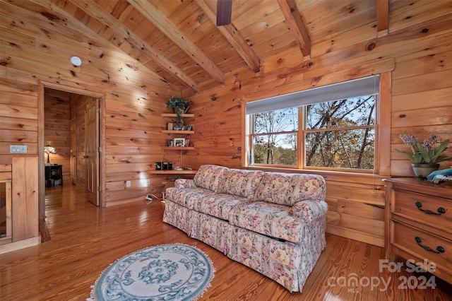 living room with wood walls, wooden ceiling, lofted ceiling with beams, ceiling fan, and light wood-type flooring