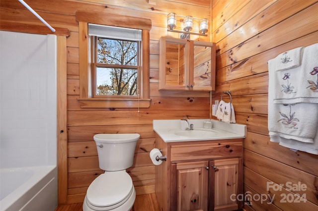 full bathroom featuring vanity, wood walls, toilet, and bathtub / shower combination