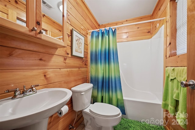 full bathroom with toilet, sink, shower / tub combo with curtain, and wood walls