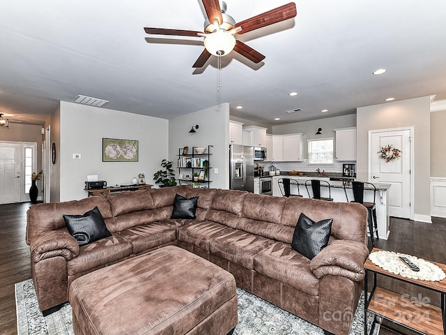 living room featuring dark hardwood / wood-style flooring and ceiling fan