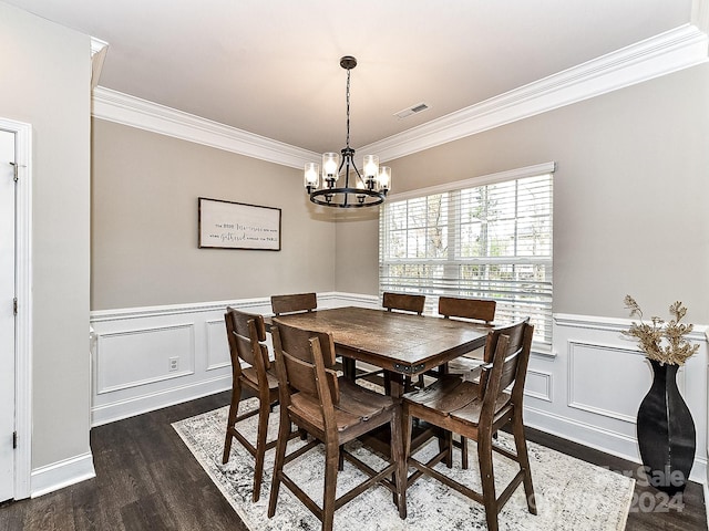 dining area with dark hardwood / wood-style flooring, an inviting chandelier, and ornamental molding