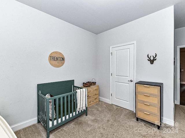 bedroom featuring carpet flooring and a crib