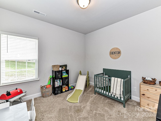 carpeted bedroom with a crib