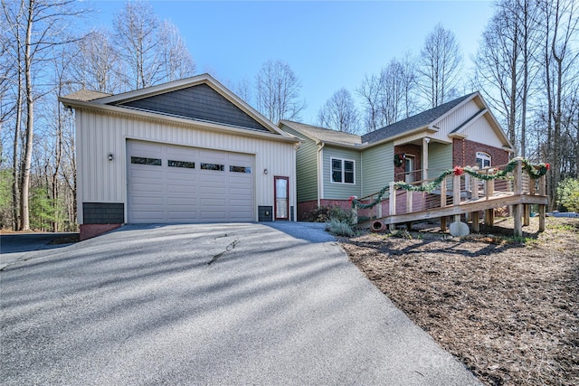 single story home featuring a garage and aphalt driveway