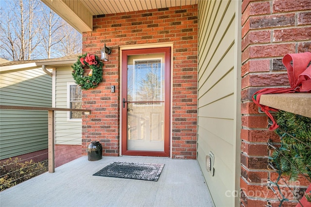 doorway to property with brick siding