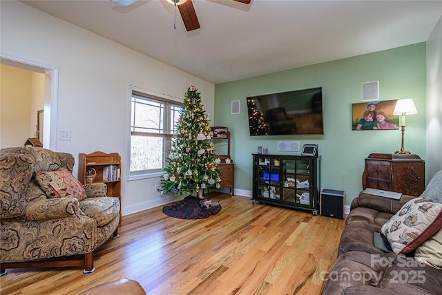 living area with ceiling fan, baseboards, and wood finished floors