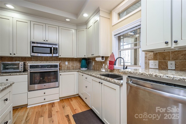 kitchen featuring tasteful backsplash, a toaster, stainless steel appliances, and a sink