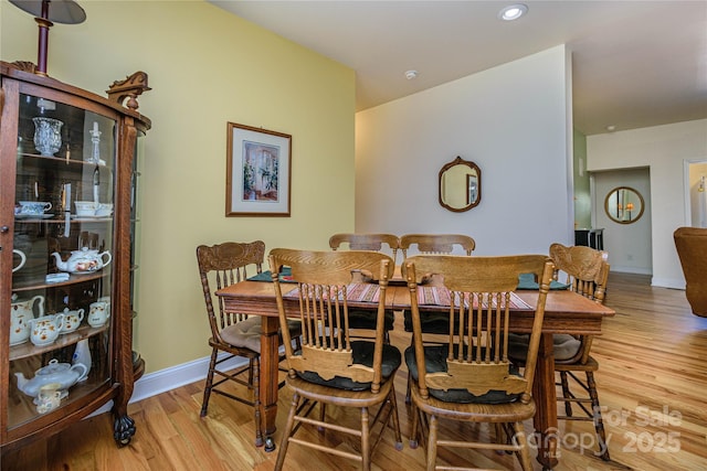 dining room featuring light wood finished floors, baseboards, and recessed lighting