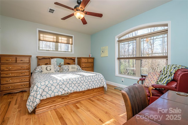 bedroom featuring a ceiling fan, baseboards, visible vents, and wood finished floors