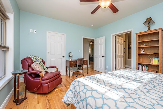 bedroom featuring a ceiling fan, light wood-style flooring, and baseboards