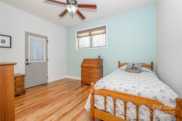 bedroom with ceiling fan, light wood-style flooring, and baseboards