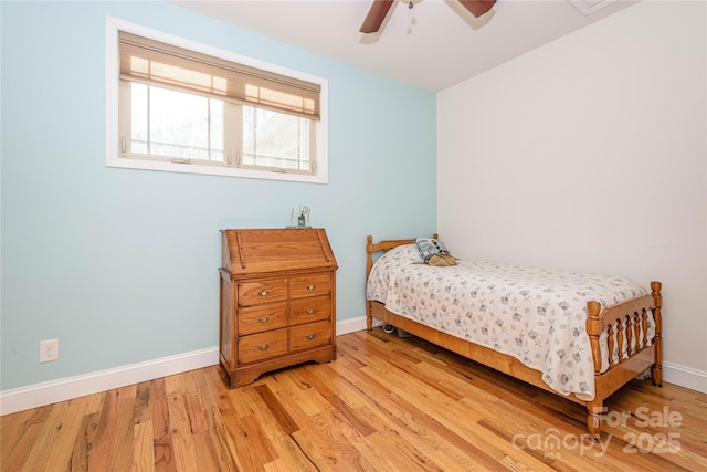 bedroom featuring ceiling fan, wood finished floors, and baseboards