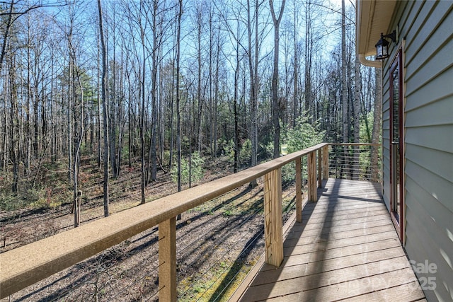 wooden deck with a wooded view