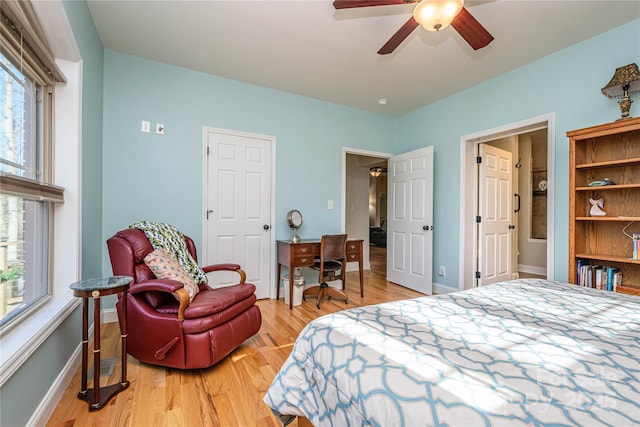 bedroom featuring ceiling fan, multiple windows, light wood-style flooring, and baseboards