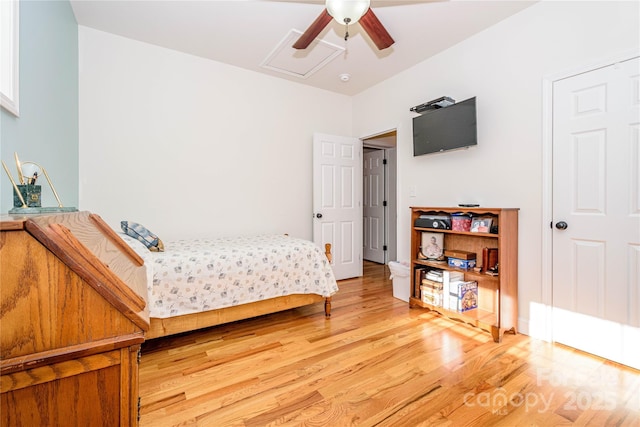 bedroom featuring light wood-style flooring and attic access