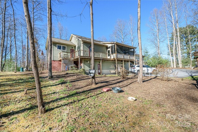 rear view of property featuring a wooden deck and a sunroom