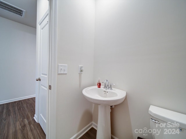 bathroom featuring hardwood / wood-style flooring and toilet