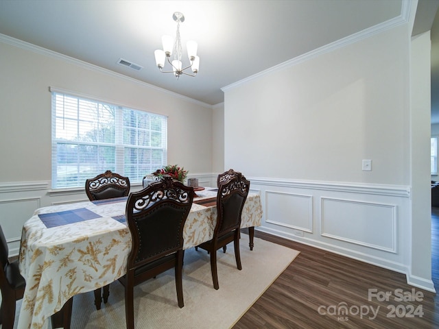 dining area featuring a chandelier, dark wood-type flooring, and ornamental molding