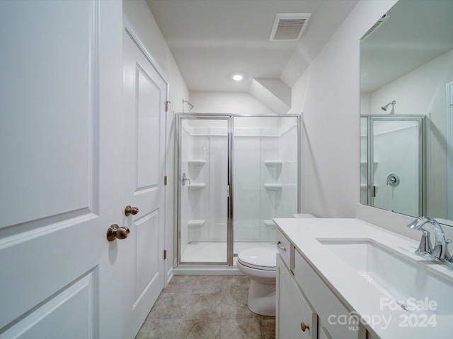 bathroom with tile patterned flooring, vanity, toilet, and walk in shower