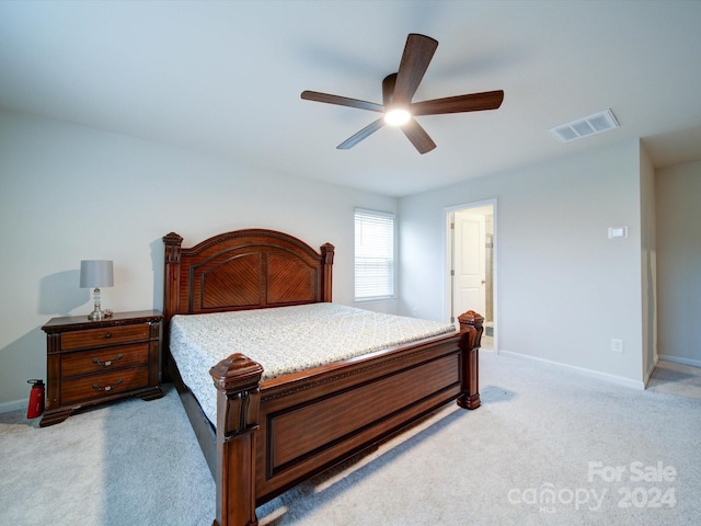 bedroom featuring connected bathroom, ceiling fan, and light colored carpet