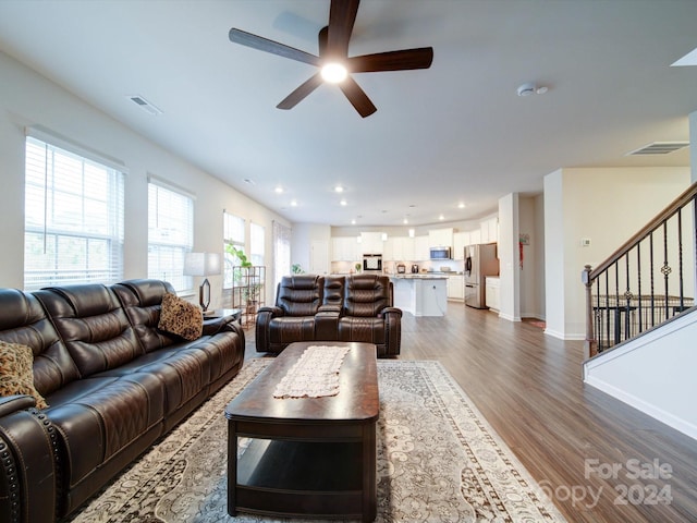 living room with ceiling fan and dark wood-type flooring