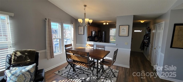 dining space featuring lofted ceiling, a notable chandelier, and dark hardwood / wood-style flooring