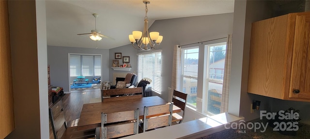 dining space featuring lofted ceiling, hardwood / wood-style floors, and ceiling fan with notable chandelier