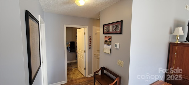 hallway with dark wood-type flooring and a textured ceiling