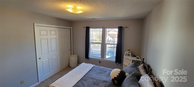 carpeted bedroom featuring a closet and a textured ceiling