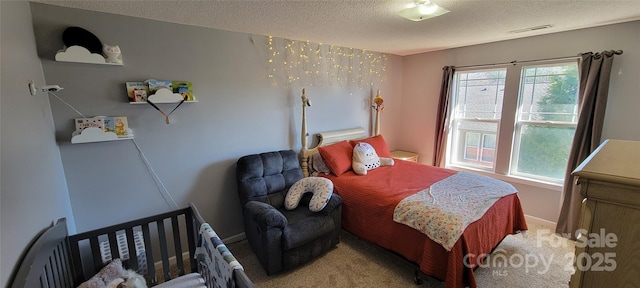 bedroom with carpet floors and a textured ceiling