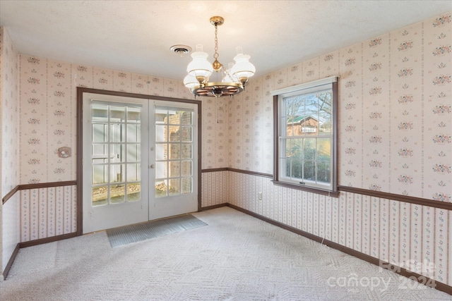 interior space with carpet, a notable chandelier, and a textured ceiling