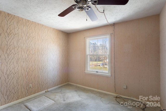 empty room featuring carpet flooring, a textured ceiling, and ceiling fan