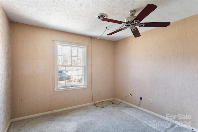 unfurnished room featuring carpet flooring, a textured ceiling, and ceiling fan