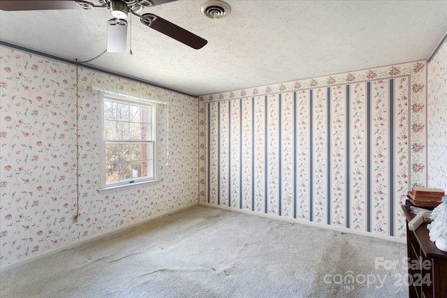 carpeted empty room with ceiling fan and a textured ceiling